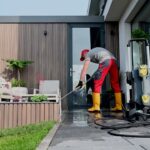 Pressure Washing Service worker cleaning a modern home patio and outdoor walkway using professional pressure washing equipment