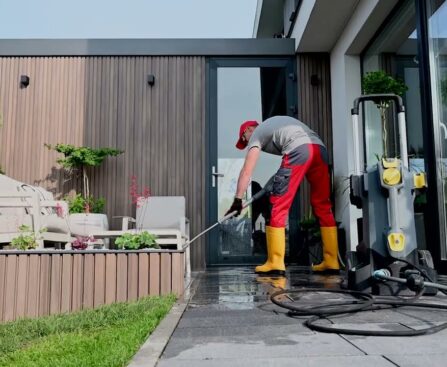 Pressure Washing Service worker cleaning a modern home patio and outdoor walkway using professional pressure washing equipment