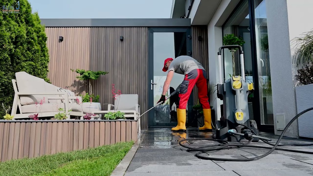 Pressure Washing Service worker cleaning a modern home patio and outdoor walkway using professional pressure washing equipment